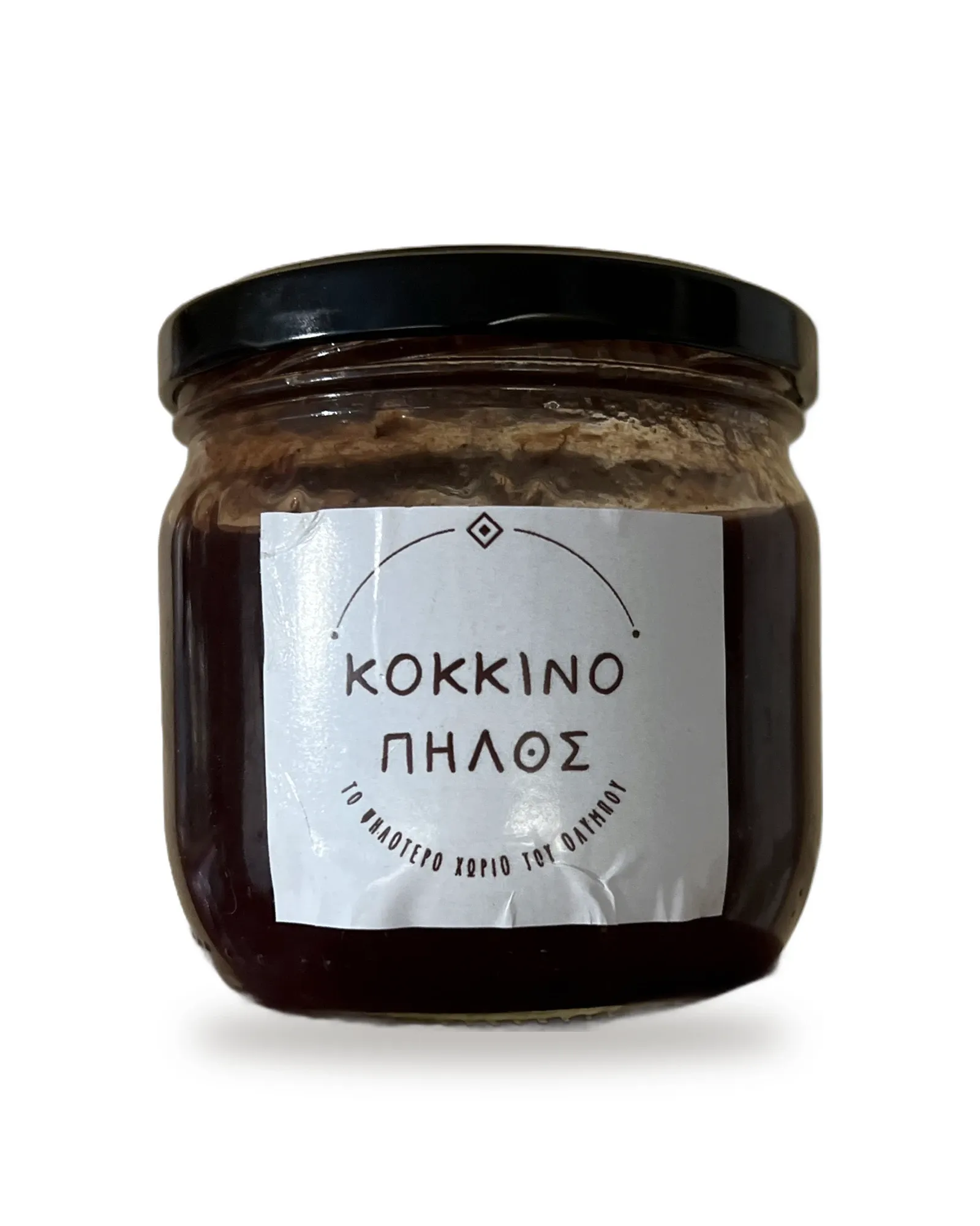 Glass jar of dark red koromilo jam with a black lid and a white Kokkinopilos label.